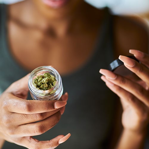 woman holding a jar of cannabis